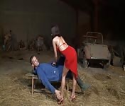 The woman in red fucks the farmer in the barn