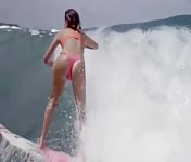 The surfer Anastasia Ashley riding a wave in thong