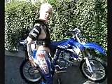 Mature big tit Carina strips out of motorbike gear outdoors