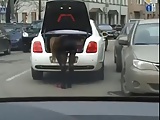 Girl changing shoes in miniskirt on street