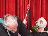 Shackled heavy woman in gas mask bound to bench with her shaved pussy wide open