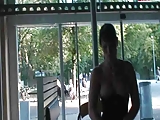 German girl rubs her pussy in front of a public window