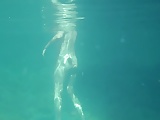 Nudists in the Crimea. Girl underwater in flippers.