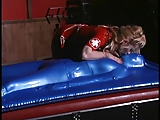 Blond Mistress covers slut in blue latex